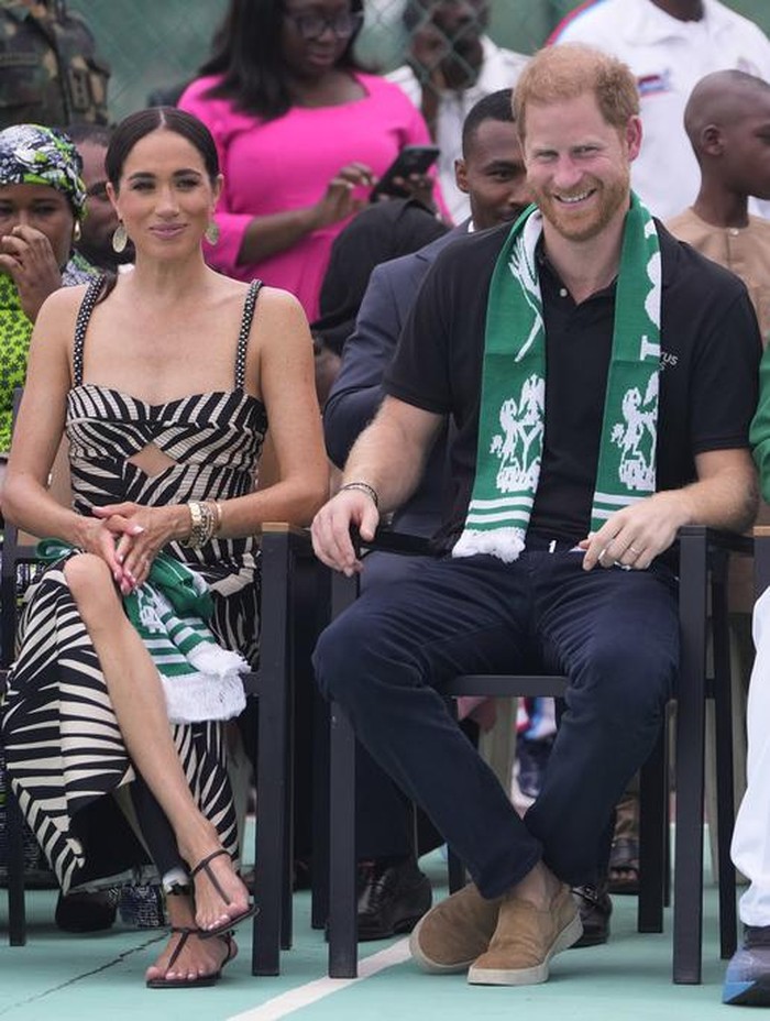 Prince Harry, left, and Meghan, right, holding hands upon arrival at the government house in Lagos Nigeria, Sunday, May 12, 2024. Prince Harry and his wife Meghan are in Nigeria to champion the Invictus Games, which Prince Harry founded to aid the rehabilitation of wounded and sick servicemembers and veterans. (AP Photo/Sunday Alamba)