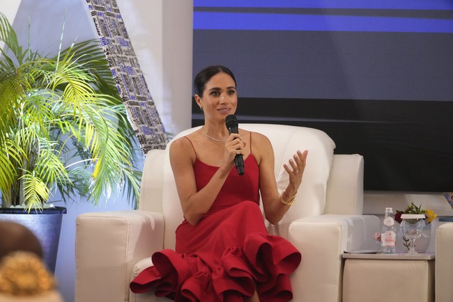 Gaun merah dengan tali spaghetti jadi pilihan Meghan Markle saat menjadi pembicara di acara Women in Leadership di Nigeria. Gaun merah tersebut dari brand lokal Nigeria, Orire.  Foto: AP Photo/Sunday Alamba