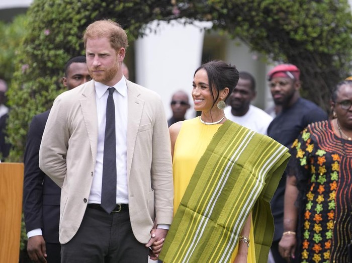 Prince Harry, left, and Meghan, right, holding hands upon arrival at the government house in Lagos Nigeria, Sunday, May 12, 2024. Prince Harry and his wife Meghan are in Nigeria to champion the Invictus Games, which Prince Harry founded to aid the rehabilitation of wounded and sick servicemembers and veterans. (AP Photo/Sunday Alamba)