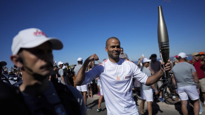 Potret Meriah Estafet Obor Olimpiade Paris French torchbearer Tony Parker participates in the first stage of the Olympic torch relay in Marseille, southern France, Thursday, May 9, 2024. Torchbearers are to carry the Olympic flame through the streets of France' s southern port city of Marseille, one day after it arrived on a majestic three-mast ship for the welcoming ceremony. (AP Photo/Thibault Camus)