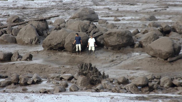 People inspect an area affected by flash flood in Agam, West Sumatra, Indonesia, Sunday, May 12, 2024. Heavy rains and torrents of cold lava and mud rushing down a volcano on Indonesia’s Sumatra island have triggered flash floods that killed more than a dozen of people and injured several others, officials said Sunday.  (AP Photo/Ali Nayaka)