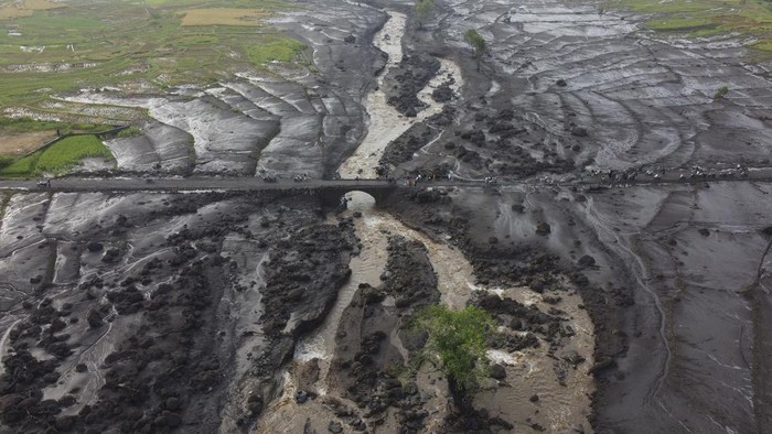 This drone photo shows the damage at a village affected by a flash flood in Tanah Datar, West Sumatra, Indonesia, Monday, May 13, 2024. Heavy rains and torrents of cold lava and mud flowing down a volcano's slopes on Indonesia's Sumatra island triggered flash floods causing a number of people dead and missing, officials said Sunday. (AP Photo/Ali Nayaka)