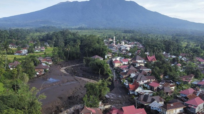 This drone photo shows the damage at a village affected by a flash flood in Tanah Datar, West Sumatra, Indonesia, Monday, May 13, 2024. Heavy rains and torrents of cold lava and mud flowing down a volcano's slopes on Indonesia's Sumatra island triggered flash floods causing a number of people dead and missing, officials said Sunday. (AP Photo/Ali Nayaka)