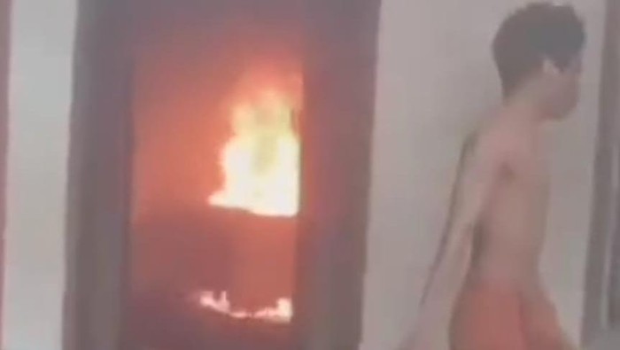 Tangkapan layar video seorang pria membakar rumahnya sendiri karena diduga kecanduan narkoba. (dok.Istimewa)
