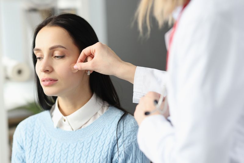 Doctor sticking adhesive plaster on patients face. Acne treatment concept