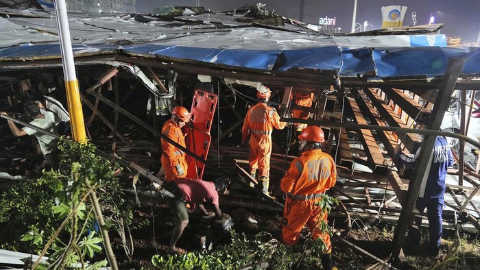 Rescuers look for victims under a billboard that collapsed following heavy rain and thundershowers in Mumbai, India, Monday, May 13, 2024. Scores of people were thought to be trapped after the collapse in the suburb of Ghatkopar, Mumbai police said on social media platform X. (AP Photo/Rafiq Maqbool)