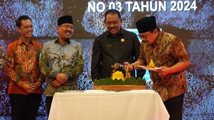 Potong tumpeng Gus Sadad dan Pakde Karwo bersama Ketua Paguyuban Kepala Desa (PKD) se-Jatim Juyanto.