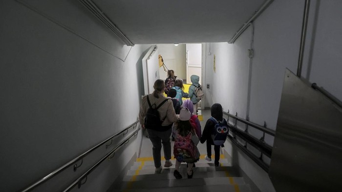 Potret Aktivitas Sekolah Bunker di Ukraina A teacher and pupils are seen in a classroom during a first lesson at the first heavily fortified underground school that allows children to safely return to in-person studies, amid Russia's attack on Ukraine, in Kharkiv, Ukraine May 13, 2024. REUTERS/Vyacheslav Madiyevskyy