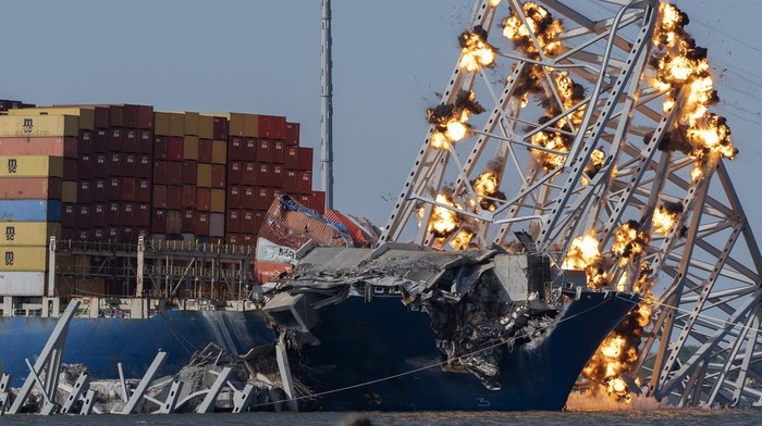 Potret Jembatan Baltimore AS Dibongkar dengan Cara Diledakkan Explosive charges are detonated to bring down sections of the collapsed Francis Scott Key Bridge resting on the container ship Dali on Monday, May 13, 2024, in Baltimore. (AP Photo/Mark Schiefelbein)