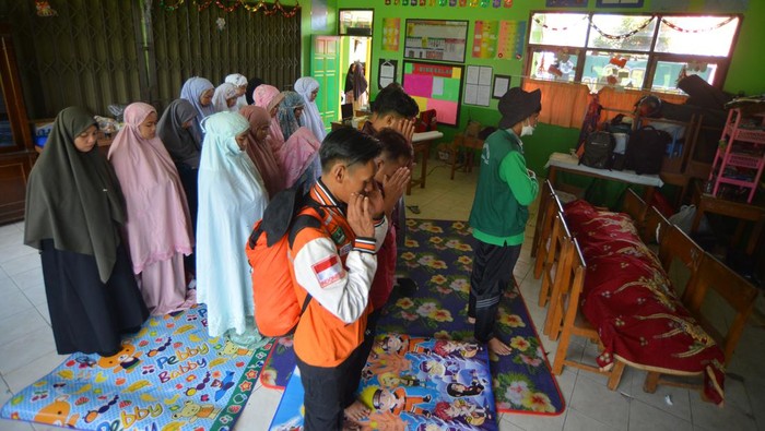 Relawan bencana bersama prajurit TNI dan warga menggotong jenazah korban banjir bandang yang baru ditemukan di Jorong Galuang, Nagari Sungai Pua, Agam, Sumatera Barat, Selasa (14/5/2024). Tim SAR gabungan bersama warga masih melakukan pencarian korban banjir bandang akibat lahar dingin Gunung Marapi pada hari ketiga dan diperkirakan masih ada satu orang lagi yang belum ditemukan di lokasi itu. ANTARA FOTO/Iggoy el Fitra/rwa.