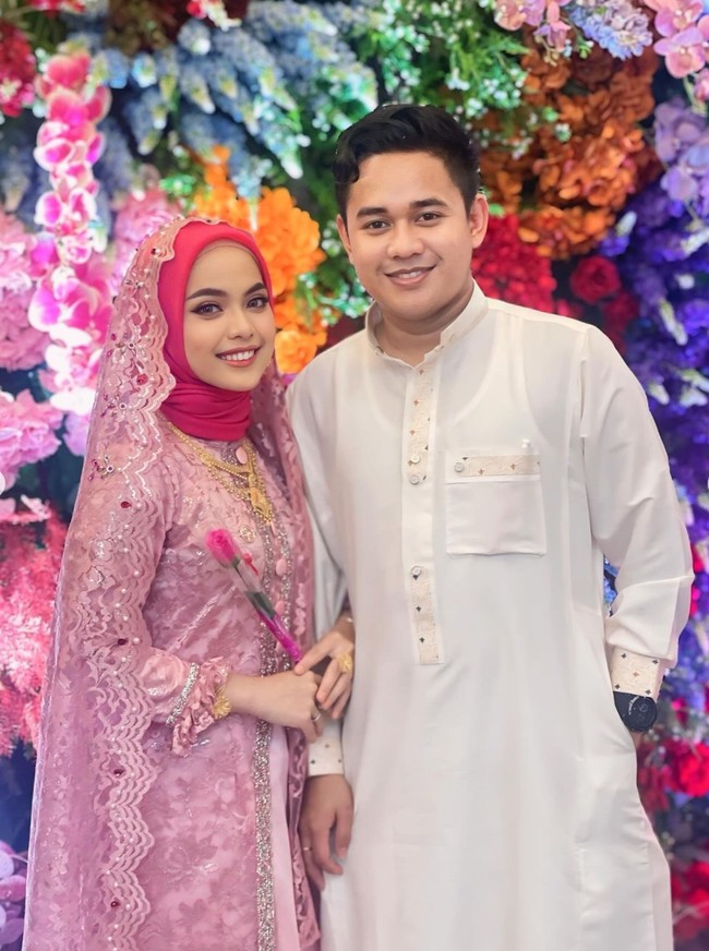 Mengenakan pakaian serba pink, Putri tampak menggandeng suaminya. Tak sedikit netizen yang berhasil dibuat salfok melihat perhiasan emas yang dikenakan wanita 20 tahun itu. Udah cantikkk baik emas nya juga dah penuh, komentar salah seorang netizen. Aduhh cantiknya Bu hj.tambah bersinar pake perhiasan emas.. bahagia selalu puzis.. tambah netizen lain. Foto: dok. Instagram/@da4_putri03