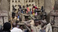Warga mengambil bagian dalam pekerjaan plesteran ulang tahunan bangunan bata lumpur terbesar di dunia, Masjid Agung Djenne, Mali, Minggu (12/5/2024). 
