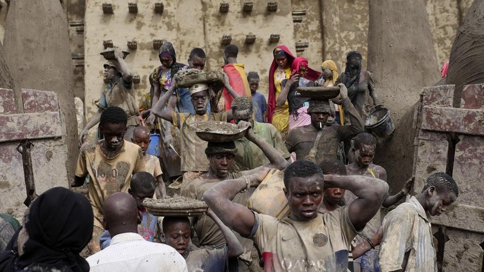 Warga Mali Gotong Royong Plester Ulang Masjid Agung dari Lumpur Malians take part in the annual replastering of the world's largest mud-brick building, the Great Mosque of Djenne, Mali, Sunday, May 12, 2024. The building has been on UNESCO's World Heritage in Danger list since 2016. The mosque and surrounding town are threatened by conflict. Djenne's mosque requires a new layer of mud each year before the start of the rainy season in June. (AP Photo/Moustapha Diallo)
