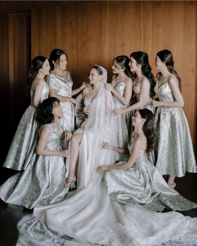 Pernikahan Enzy Storia mencuri perhatian dengan para pendamping yang datang dari kalangan artis. Kamu bisa contek inspirasi gaun bridesmaid dari pernikahan Enzy Storia yang tampil dalam balutan gaun klasik silver berbahan jacquard.  Foto: Instagram