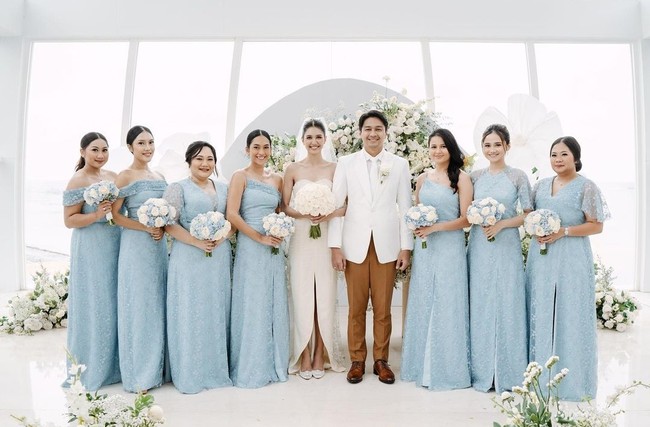 Perpaduan kain satin dan brokat dengan gaya sabrina dari pernikahan Mikha Tambayong dan Deva Mahenra ini bisa menjadi inspirasi gaun bridesmaid. Pemilihan warna biru muda untuk pengiring pengantinnya menghasilkan nuansa yang anggun dan lembut. Foto: Instagram