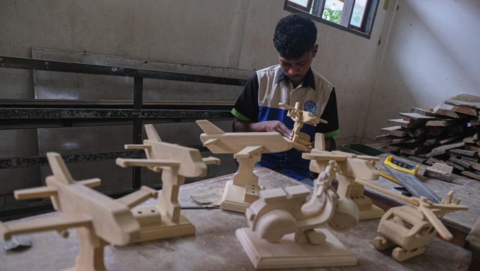 Siswa menyelesaikan pembuatan miniatur pesawat dan motor vespa dari kayu di SMKN 4 Kendari, Sulawesi Tenggara, Rabu (15/5/2024). Pihak sekolah melakukan kegiatan keterampilan tambahan dengan memberi tugas kepada siswa untuk membuat miniatur dari sisa limbah kayu guna meningkatkan kemampuan siswa. ANTARA FOTO/Andry Denisah/YU