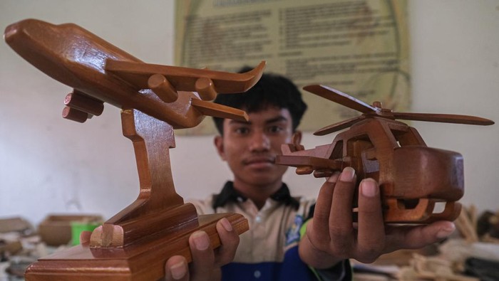 Siswa menyelesaikan pembuatan miniatur pesawat dan motor vespa dari kayu di SMKN 4 Kendari, Sulawesi Tenggara, Rabu (15/5/2024). Pihak sekolah melakukan kegiatan keterampilan tambahan dengan memberi tugas kepada siswa untuk membuat miniatur dari sisa limbah kayu guna meningkatkan kemampuan siswa. ANTARA FOTO/Andry Denisah/YU