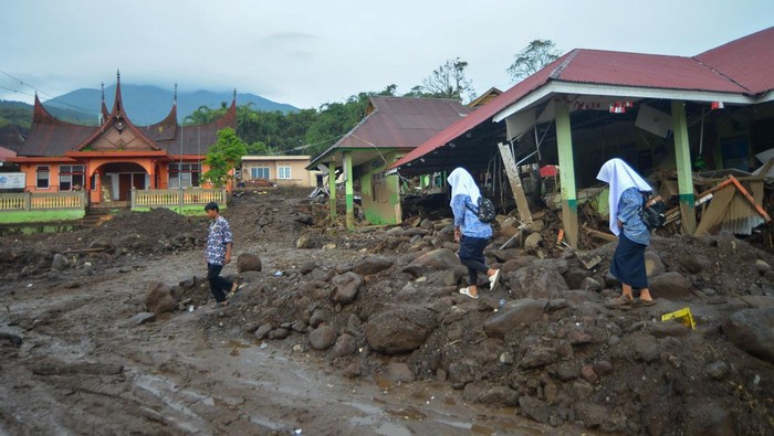 Pelajar melintas di depan sekolah yang hancur akibat banjir bandang di Jorong Galudua, Nagari Koto Tuo IV Koto, Agam, Sumatera Barat, Rabu (15/5/2024). Banjir bandang yang terjadi pada Sabtu (11/05/2024) dari aliran sungai Gunung Singgalang itu juga mengakibatkan sejumlah bangunan dan fasilitas umum di kampung tersebut hancur.  ANTARA FOTO/Iggoy el Fitra/YU