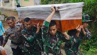Personel TNI dan kepolisian menggotong peti berisi jenazah korban banjir bandang untuk dimakamkan di Jorong Pagu-pagu, Nagari Pandai Sikek, Tanah Datar, Sumatera Barat, Selasa (14/5/2024).