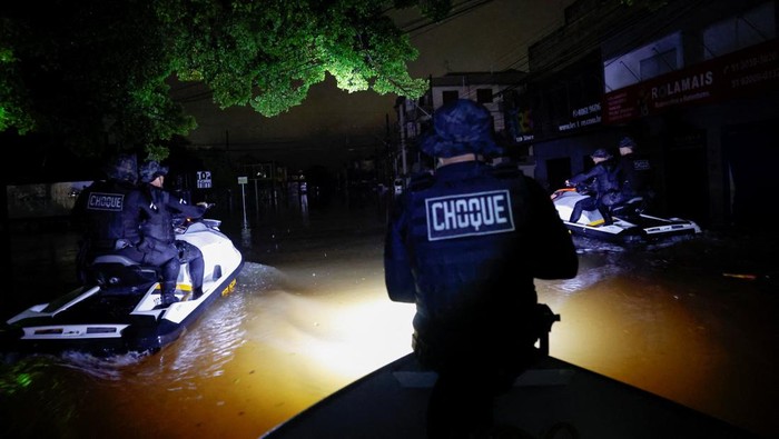 Kriminal Meningkat Saat Banjir, Polisi Brasil Perketat Keamanan A police officer holds a rifle while patrolling on a boat in a flooded area to prevent theft in the downtown of Porto Alegre,Rio Grande do Sul state, Brazil, May 12, 2024. REUTERS/Adriano Machado