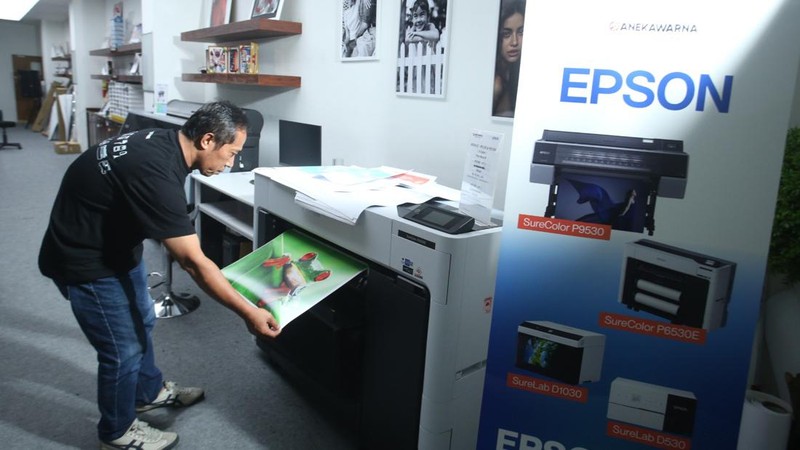Petugas mencetak foto menggunakan printer Epson di Galeri Aneka Warna, Jakarta, Rabu (15/5/2024).
