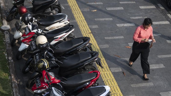 Warga berjalan di dekat sepeda motor yang terparkir di jalur pedestrian kawasan Salemba, Jakarta, Senin (13/5/2024). Pemprov DKI Jakarta meminta Dishub DKI Jakarta untuk menertibkan parkir liar di seluruh wilayah Jakarta dengan mengedepankan prosedur penertiban secara manusiawi. ANTARA FOTO/Aprillio Akbar