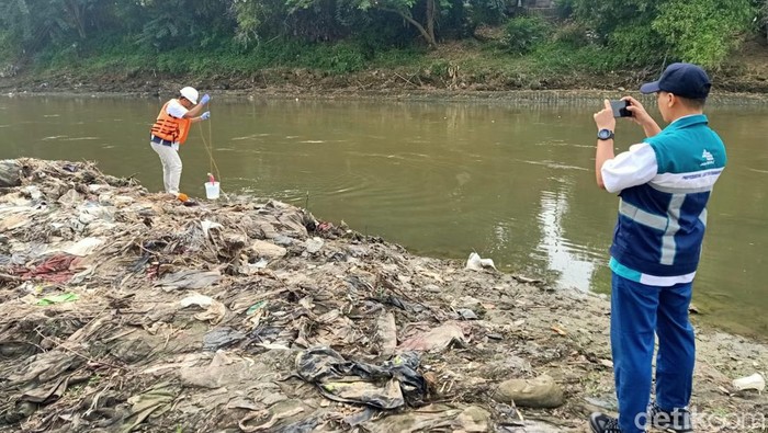Petugas perum jasa tirta I mengambil sampel air di Bangawan Solo di Kampung Sewu, Rabu (15/5/2024).