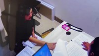 Sandra tampak mengenakan pakaian hitam. Dia duduk di depan penyidik yang memakai seragam merah. (dok. Istimewa)