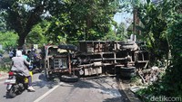 Truk itu terguling dan menutup setengah lajur jalan.