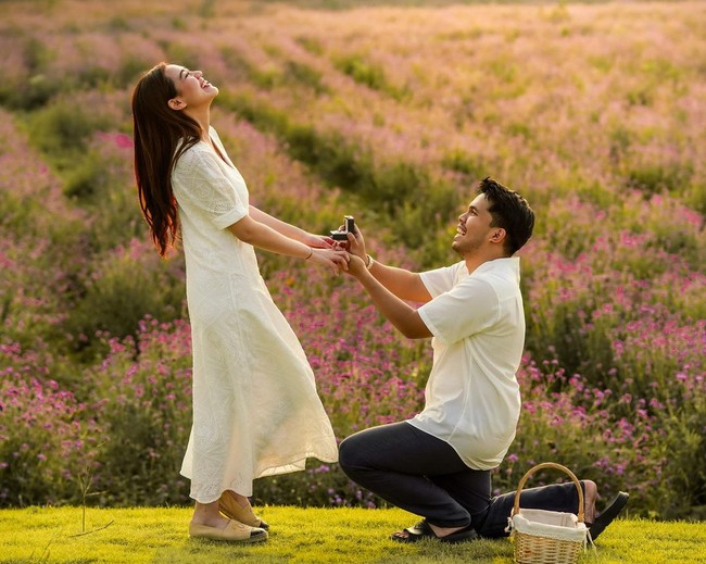 Salah satu foto memperlihatkan Thariq berlutut sambil menyodorkan cincin kepada Aaliyah dengan latar hamparan padang berbunga ungu. Mereka tampak serasi dengan baju serba putih. (Foto: instagram Thariq Halilintar)