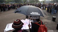 Mereka juga membawa payung hitam dan berorasi. 