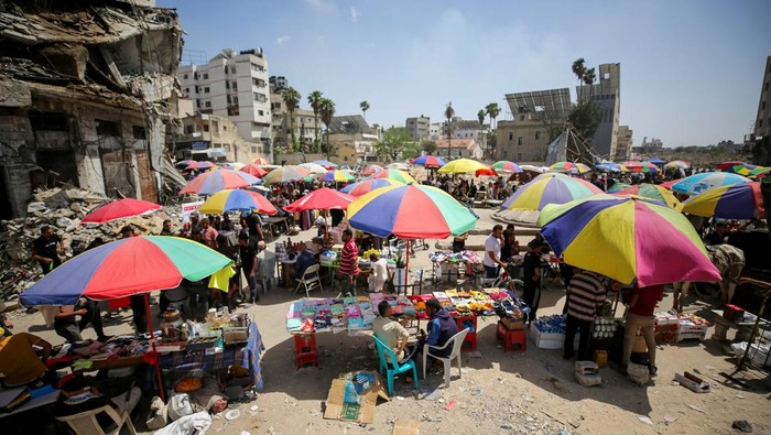 Gaza Dilanda Krisis Uang Tunai Imbas Perang Berbulan-bulan Palestinian vendors sell goods near a destroyed building housing Bank of Jordan, amid a cash crunch caused by the destruction and closure of banks, as conflict between Israel and Hamas continues, in Gaza City May 5, 2024. REUTERS/Dawoud Abu Alkas TPX IMAGES OF THE DAY