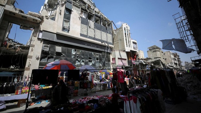 Gaza Dilanda Krisis Uang Tunai Imbas Perang Berbulan-bulan Palestinian vendors sell goods near a destroyed building housing Bank of Jordan, amid a cash crunch caused by the destruction and closure of banks, as conflict between Israel and Hamas continues, in Gaza City May 5, 2024. REUTERS/Dawoud Abu Alkas TPX IMAGES OF THE DAY