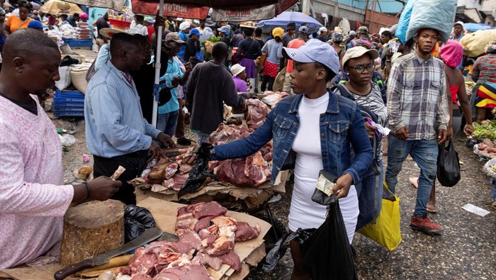 A woman pays for meat purchased at the Petionville street market in Port-au-Prince, Haiti May 2, 2024. REUTERS/Ricardo Arduengo