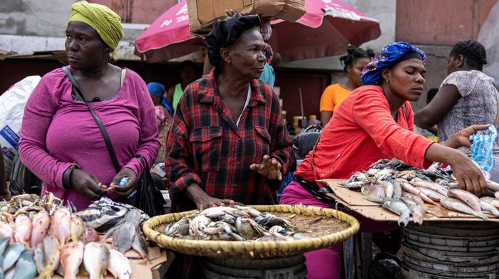 A woman pays for meat purchased at the Petionville street market in Port-au-Prince, Haiti May 2, 2024. REUTERS/Ricardo Arduengo