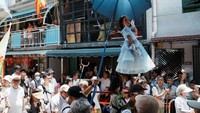 Kerumunan orang memadati jalan-jalan. Mereka bersemangat menyaksikan parade Piu Sik yang menampilkan anak-anak melayang. Anak-anak tersebut dianggap sebagai dewa yang dihormati dan tokoh politik saat ini. 
