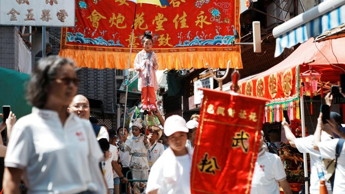Meriahnya Pawai Anak-anak 'Melayang' di Hong Kong A child stands above the crowd with the support of an elaborate rig of hidden metal rods during the Bun Festival parade at Cheung Chau Island in Hong Kong, China May 15, 2024. REUTERS/Lam Yik
