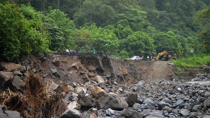 Penampakan Jalan Nasional Porak-poranda Imbas Banjir Bandang di Sumbar Warga menyaksikan alat berat bekerja untuk menangani jalan putus di kawasan Lembah Anai, Nagari Singgalang, Tanah Datar, Sumatera Barat, Kamis (16/5/2024). Pemerintah mengerjakan sebanyak 16 titik jalan rusak di sepanjang jalan nasional Padang - Bukittinggi termasuk jalan putus akibat banjir bandang tersebut dan akan melakukan penanganan darurat sebelukan pembangunan permanen. ANTARA FOTO/Iggoy el Fitra/Spt.