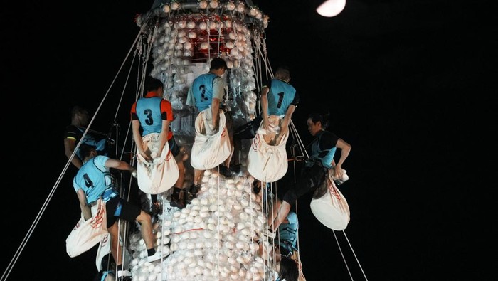 A man walks past bun towers during Bun Festival at Cheung Chau island in Hong Kong, China May 15, 2024. REUTERS/Lam Yik