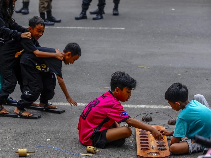 Sejumlah anak bermain gasing di Rangkasbitung, Lebak, Banten, Kamis (16/5/2024).  Pengenalan permainan tradisional tersebut bertujuan untuk mengedukasi anak-anak tentang permainan tradisional khas Indonesia sekaligus mengajak masyarakat untuk melestarikan permainan tersebut. 
ANTARA FOTO/Muhammad Bagus Khoirunas/nz