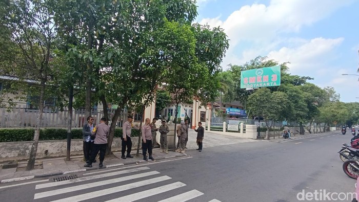 Tampak polisi berjaga di depan SMKN 3 Jogja usai insiden pelemparan petasan oleh rombongan pemotor, Kamis (16/5/2024).