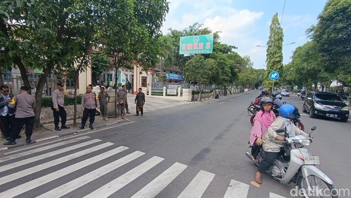 Tampak polisi berjaga di depan SMKN 3 Jogja usai insiden pelemparan petasan oleh rombongan pemotor, Kamis (16/5/2024).