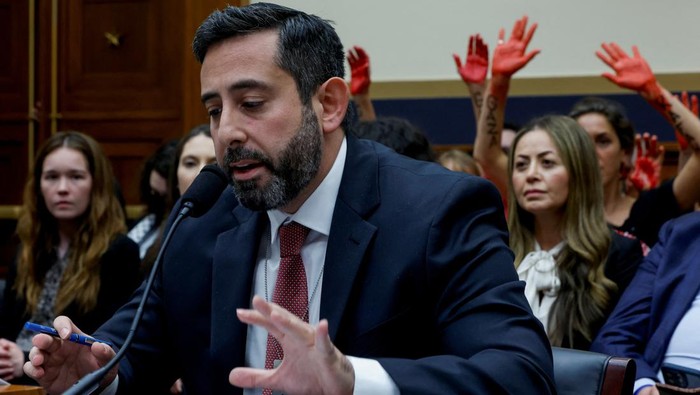 'Tangan-tangan Merah' Iringi Sidang soal Demo Bela Palestina di Kampus AS Demonstrators in support of Gaza raise red hands behind Rabbi Mark Goldfeder, CEO of National Jewish Advocacy Center, a witness at the House Judiciary Subcommittee hearing on