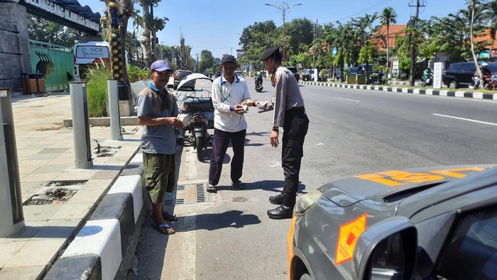 Anggota Samapta Polresta Sidoarjo membagikan makanan saat patroli