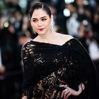 Penampilan Araya Hargate di Festival Film Cannes 2024 mencuri perhatian karena pilihan busananya yang mengekspos tubuhnya. Araya mengenakan lace dress karya Maison Margiela. Foto: LOIC VENANCE / AFP