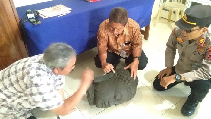 Kapolsek Nogosari, AKP Riyanto bersama petugas melihat kondisi patung berbentuk mirip kepala Buddha yang ditemukan di sungai.