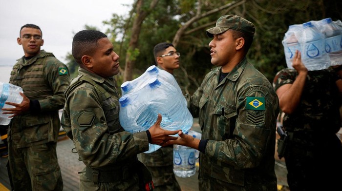 Militer Brasil Distribusikan Bantuan Air Bersih untuk Korban Banjir Brazilian soldiers carry donations from a navy ship on the Guaiba Lake in Porto Alegre, state of Rio Grande do Sul, Brazil May 16, 2024.REUTERS/Adriano Machado REFILE - CORRECTING FROM