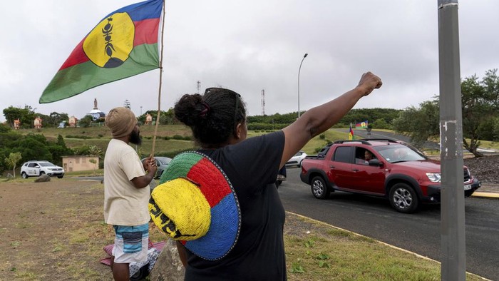 Potret Mencekam Saat Kerusuhan Pecah di Kaledonia Baru A woman waves a Kanak and Socialist National Liberation Front (FLNKS) flag in Noumea, New Caledonia, Wednesday May 15, 2024. France has imposed a state of emergency in the French Pacific territory of New Caledonia. The measures imposed on Wednesday for at least 12 days boost security forces' powers to quell deadly unrest that has left four people dead, erupting after protests over voting reforms. (AP Photo/Nicolas Job)