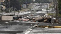 Dengan penetapan kondisi darurat, otoritas setempat punya kuasa untuk melarang perkumpulan massa dan melarang orang untuk bepergian. AP/Nicolas Job