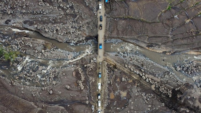 Antrean kendaraan di jalan terdampak banjir bandang Foto udara kendaraan antre melewati jembatan yang terdampak banjir bandang di jalan penghubung Nagari Rambatan dengan Nagari Limo Kaum, Tanah Datar, Sumatera Barat, Jumat (17/5/2024). Jalan pedesaan yang menjadi jalur alternatif ke kabupaten lain pascabanjir bandang lahar dingin Gunung Marapi itu dipadati kendaraan yang harus melintas secara bergantian karena ukuran jembatan yang kecil. ANTARA FOTO/Iggoy el Fitra/tom.